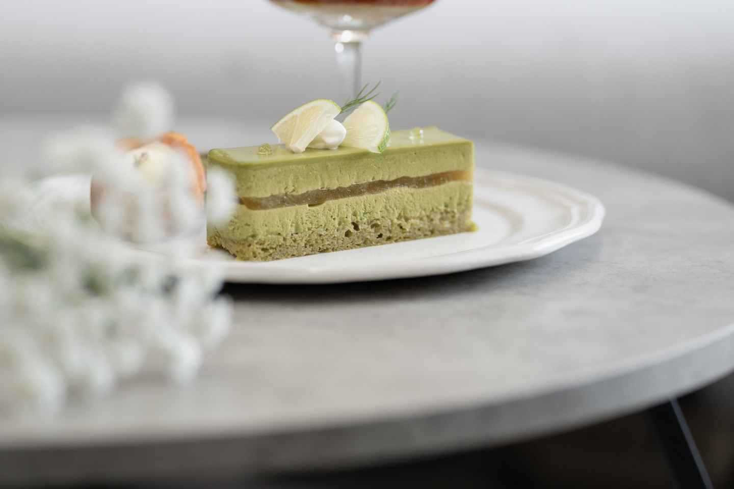 白い皿にのせた、抹茶のケーキ