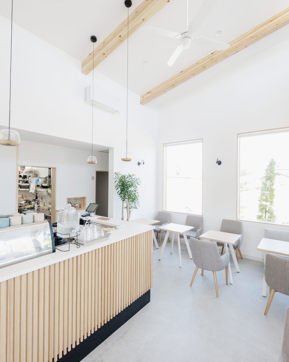 木のカウンターと白い壁の、明るいカフェの店内